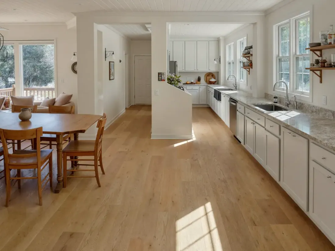 Kitchen and dining room with new light wood floors and freshly painted walls