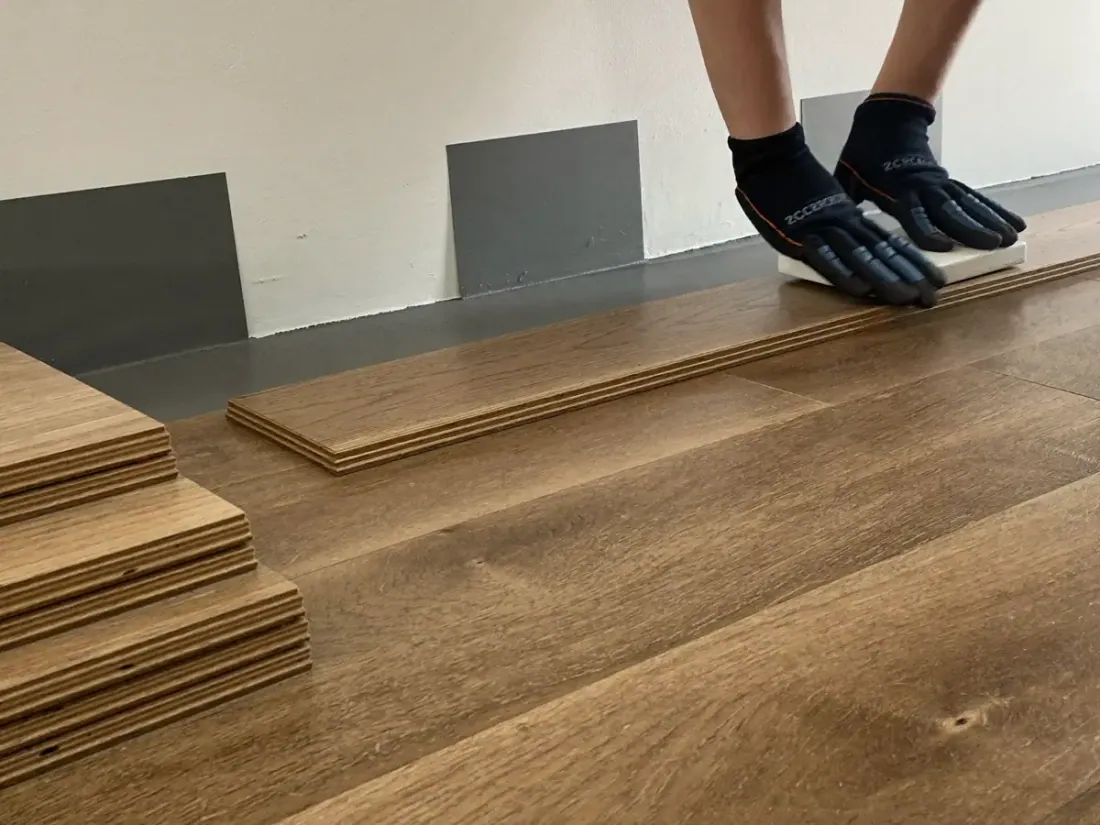 New wood-look flooring planks being installed in a Winnsboro, TX home